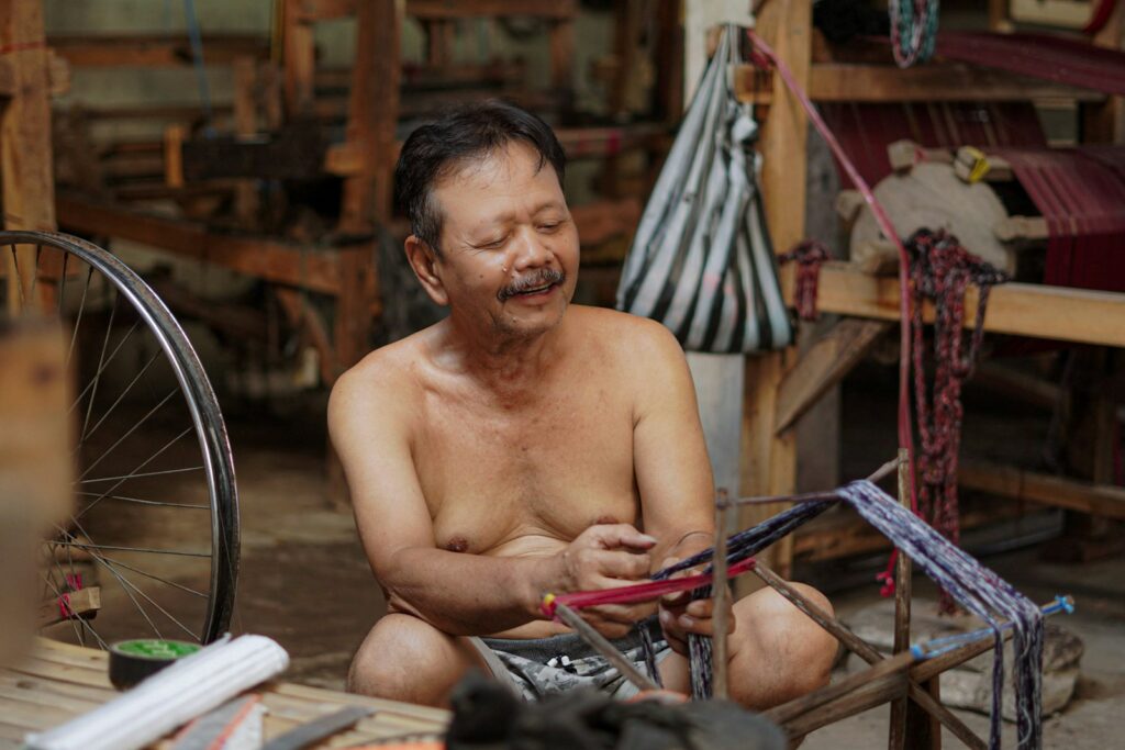 A man sitting on the ground next to a bike